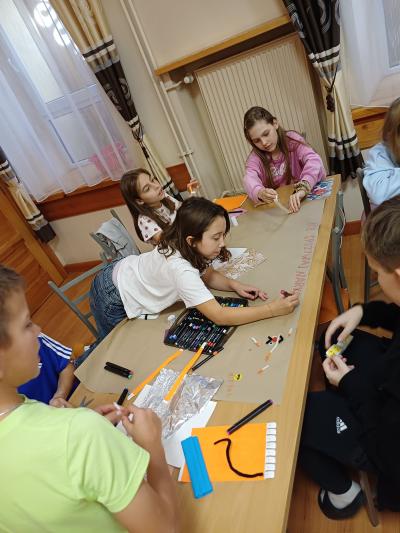 Uczniowie wykonują plakat na temat uzależnień.