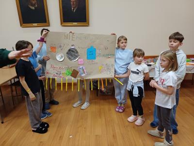 Uczniowie prezentują plakat o uzależnieniach.