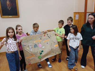 Uczniowie prezentują plakat o uzależnieniach.