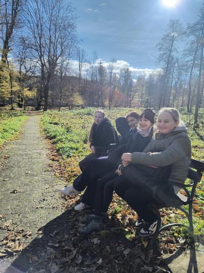 Uczniowie siedza na ławce w Gorczańskim Parku Narodowym.