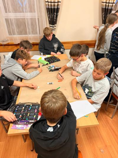 Uczniowie wykonują plakat na temat uzależnień.