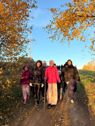 Uczniowie spacerują wśród pól i drzew.