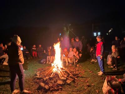 Uczniowie palą ognisko. Jest ciemno.