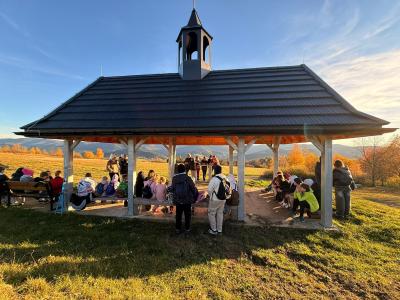 Uczniowie siedzą koło ołtarza polowego na Potaczkowej Górze.