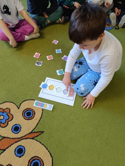 Dziecko układa obrazki z dyniami.