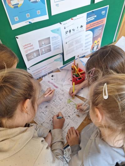 Uczniowie malują kolorowanki i rozwiązują łamigłówki.