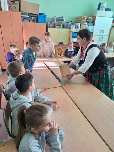 Pani z Koła Gospodyń Wiejskich pokazuje dzieciom zrobione masło.