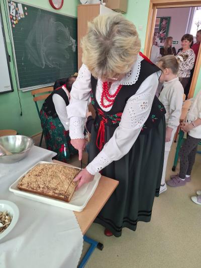 Pani z Koła Gospodyń Wiejskich kroi swojską buchtę.