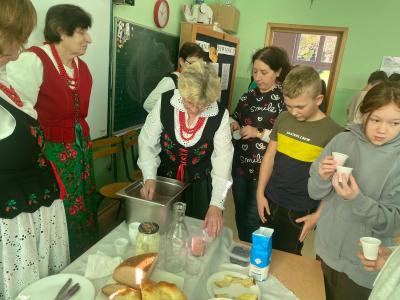 Uczniowie degustują zrobiony koktajl owocowy.