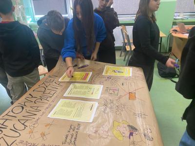 Uczniowie tworzą plakat na temat rzucania palenia.