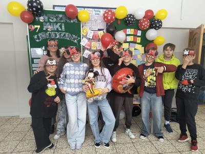 Uczniowie stoją w grupie w okularach z symbolami związanymi z Myszką Mickey.