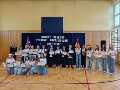 Zwycięskie i wyróżnione zespoły pozują do wspólnego zdjęcia. Zwycięzcy trzymają w rękach dyplomy i nagrody.