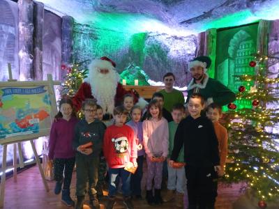 Uczniowie wraz z elfem św. Mikołaja pozują do zdjęcia grupowego.