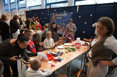 Rodzice wraz z dziećmi wykonują świąteczne krasnale.