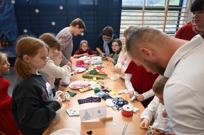 Rodzice wraz z dziećmi robią świąteczne krasnale.