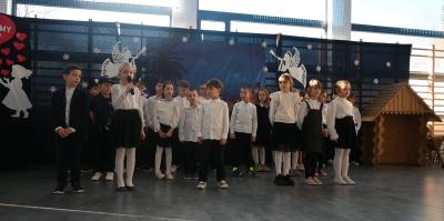 Uczniowie stoją na scenie i recytują swoje role.