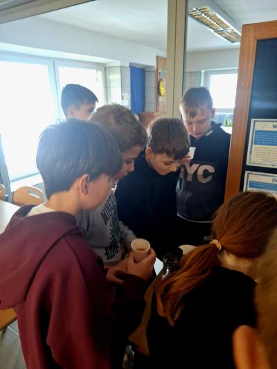 Uczniowie piją wodę z dodatkami.