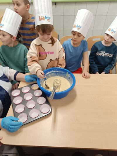 Dziecko miesza ciasto w misce.