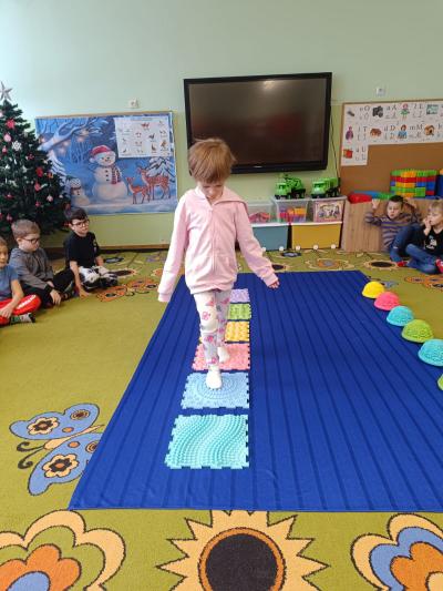 Dziecko chodzi po ścieżce sensorycznej.