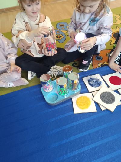 Dzieci pracują z pomocami sensorycznymi - podświetlane kuleczki.