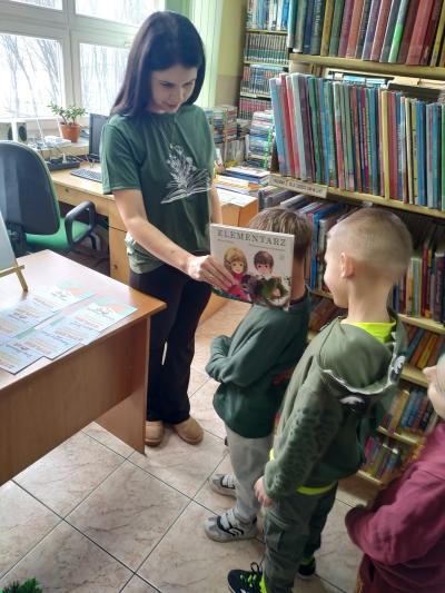 Pani bibliotekarka pasuje uczniów na czytelnika.
