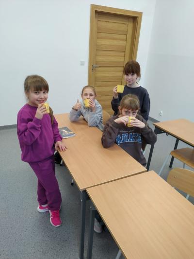 Uczennice piją sok z kubków.