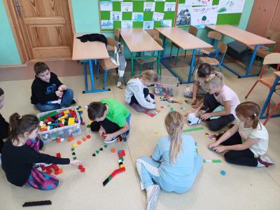 Uczniowie budują i kodują trasę dla robota Photon.