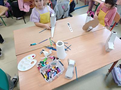 Uczniowie tworzą zwierzęta z kartonu.