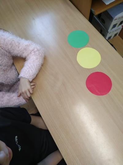 Kółka w kolorach zielonym, żółtym i czerwonym leżą na ławce.