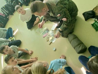 Żołnierz pokazuje wyposażenie plecaka.