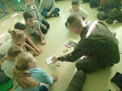 Żołnierz pokazuje wyposażenie plecaka.