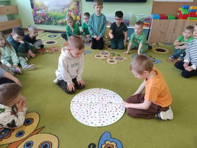 Dzieci grają w wiosenne double na dywanie.