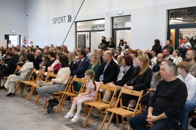 Uczniowie i rodzice oraz zaproszeni goście siedzą na krzesłach, jako widownia.