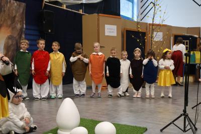 Przedszkolaki przebrane za kolorowe jajka.