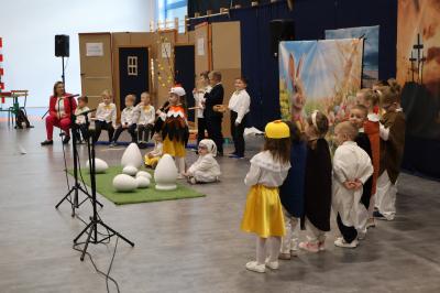 Na scenie przedszkolaki przebrane za kurę, kurki, baranka, zająca oraz jajka.
