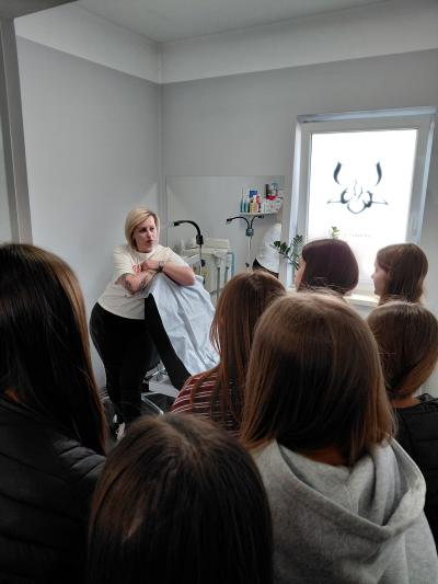 Uczniowie słuchają pani w pokoju zabiegowym.