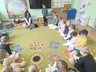 Przedszkolaki uczą się masażu serca na swoich maskotkach.