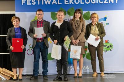 Jury i uczniowie wraz z dyplomami stoją na scenie