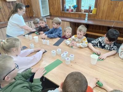 Przedszkolaki robią świece z pszczelego wosku.