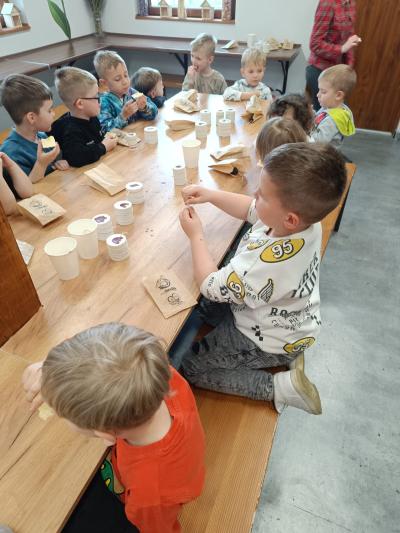 Przedszkolaki robią świece z pszczelego wosku.