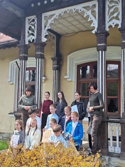 Zwycięzcy konkursu stoją w grupie przed budynkiem Nadleśnictwa Sucha Beskidzka.