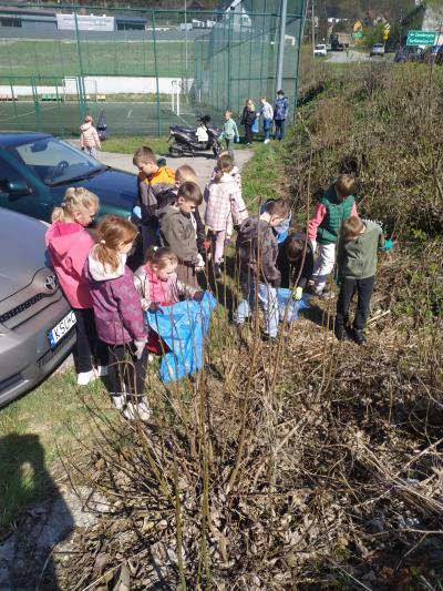 Uczniowie zbierają śmieci koło rzeki i Orlika.
