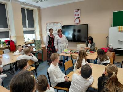 Uczniowie oglądają, jak się szyje na maszynie.