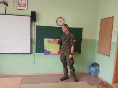 Żołnierz omawia mapę Polski.