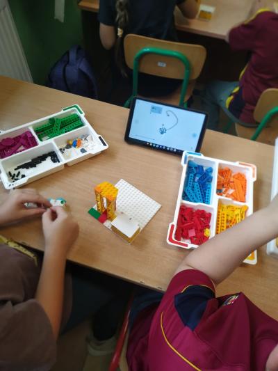 Uczniowie budują roboty z klocków LEGO.